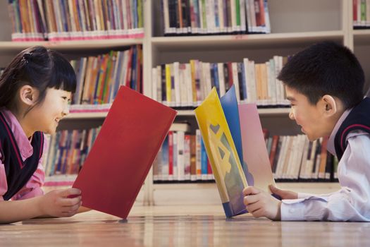 School children reading books in the library