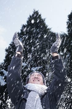 Man with arms raised feeling the snow
