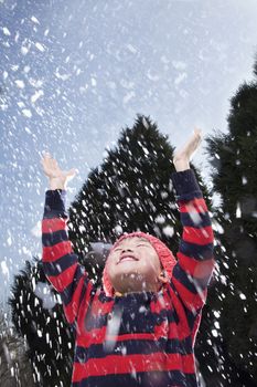 Boy with arms raised feeling the snow