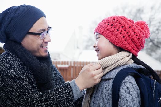 Father fixing daughter's scarf