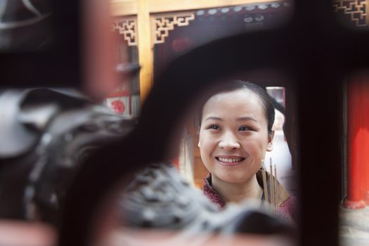 Woman holding incense, temple, Beijing