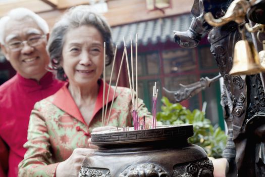 Senior couple offering incense at the temple, Beijing