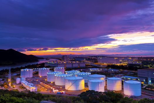 Industrial oil tanks at sunset