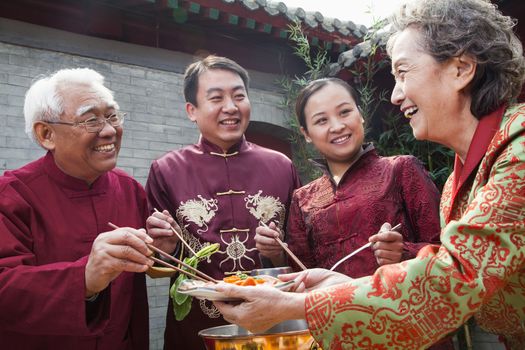 Family enjoying Chinese meal in traditional Chinese clothing