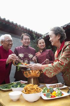 Family enjoying Chinese meal in traditional Chinese clothing