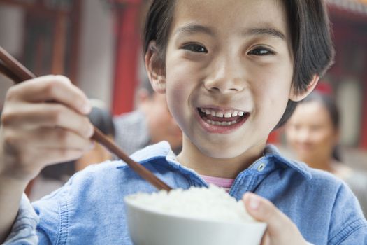 Portrait of little girl eating rice