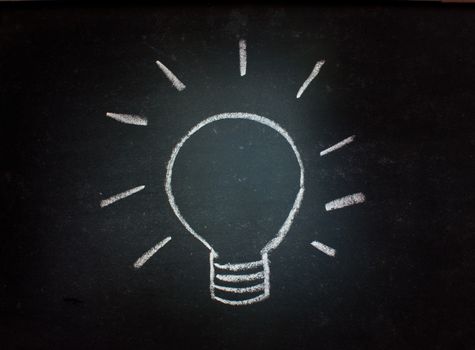 Light bulb sketched on a blackboard representing ideas and inspiration, or energy and power