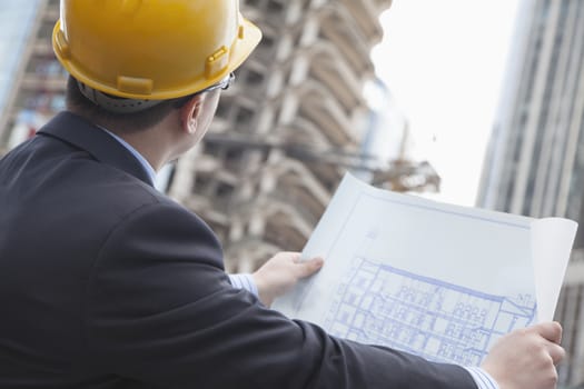 
Architect on site looking at blueprints
