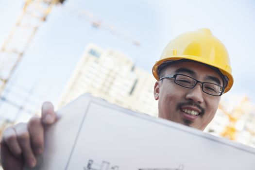 Smiling Architect looking at blueprint