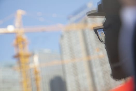 Close-up of reflection of architect on construction site   