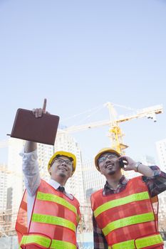 Two architects looking and pointing at construction site