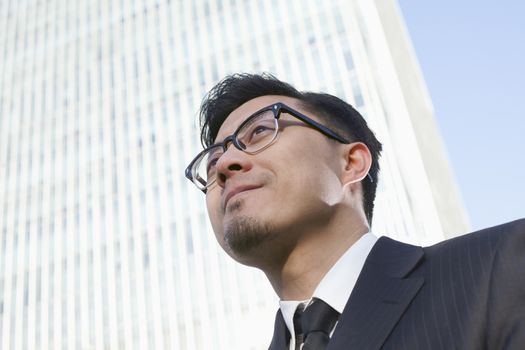 Portrait of young businessman by the world trade center in Beijing, China