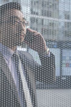 Businessman on the phone on other side of glass wall