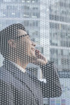 Businessman on the phone on other side of glass wall