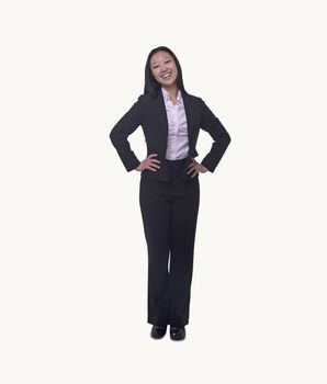 Portrait of smiling  young businesswoman with hands on hips looking at camera, full length, studio shot