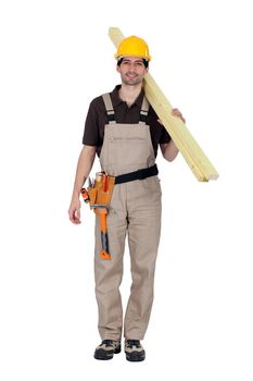 A builder carrying wooden planks