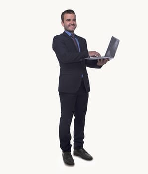 Portrait of smiling young businessman holding an open laptop, full length, studio shot