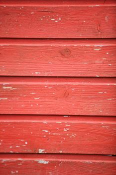 Background texture of old weathered red painted wooden planks with peeling paint and woodgrain