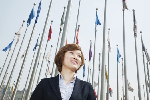Portrait of smiling young businesswoman with flags
