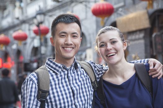 Portrait of young couple with Chinese Architecture in background.