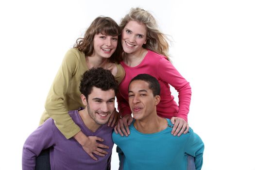 Two couples racing a piggy back race.