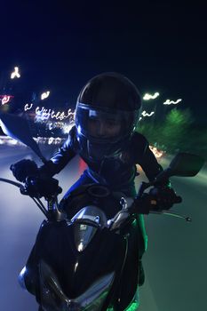 Young woman riding a motorcycle through the streets of Beijing, front view