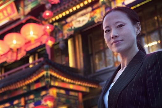 Portrait of businesswomen with Chinese architecture in background.