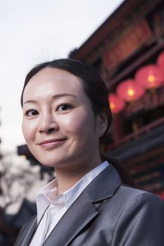 Portrait of businesswomen with Chinese architecture in background.
