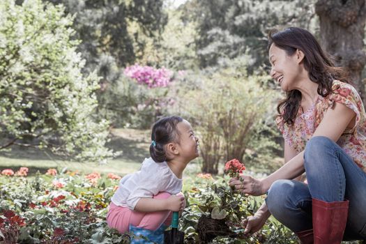 Mother and daughter planting flowers.