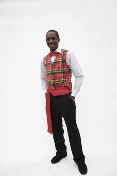 Portrait of young man in plaid vest and red bow tie, traditional clothing from Africa, studio shot