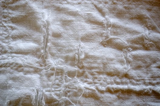 linen pant fabric closeup with long messy thread twist pattern background.