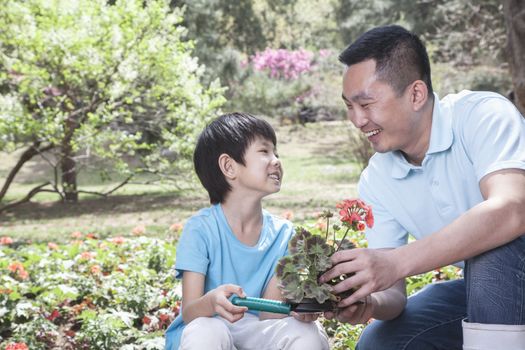 Father and son planting flowers.