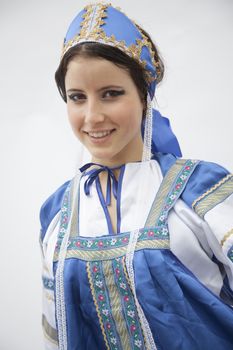 Portrait of young smiling woman in traditional clothing from Russia, studio shot