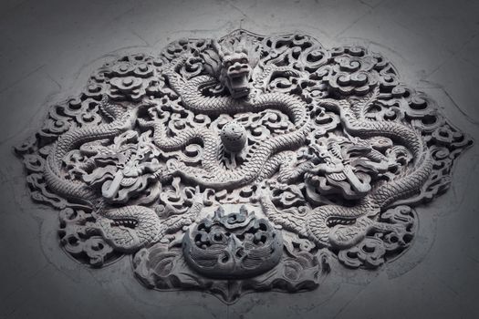 Ornate low relief sculpture of dragon on wall.