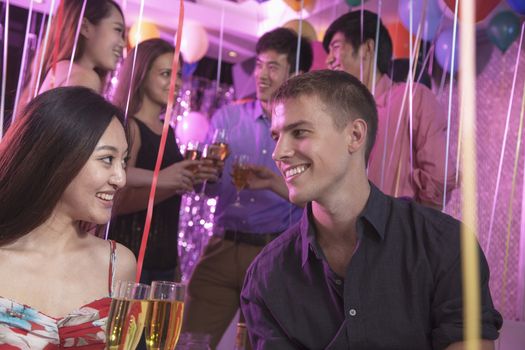 Group of friends celebrating, toasting with champagne, nightclub in Beijing