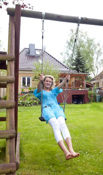 happy young blond woman swinging