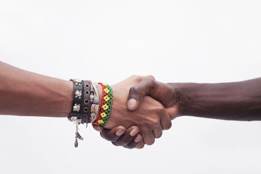 Young woman and man shaking hands, close-up, studio shot