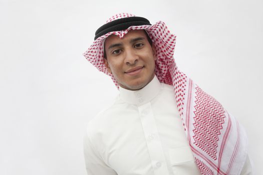 Portrait of smiling teenage boy in traditional Arab clothing, studio shot