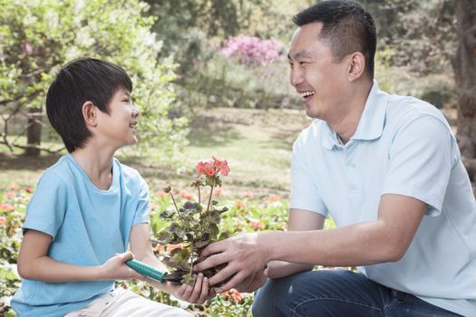 Father and son planting flowers.