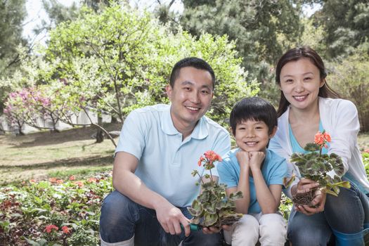 Portrait of family planting flowers.