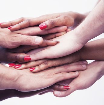 Close-up on a pile of hands on top of each other, multi-ethnic group of people, studio shot