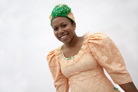 Portrait of young smiling  woman in traditional clothing from the Caribbean, studio shot