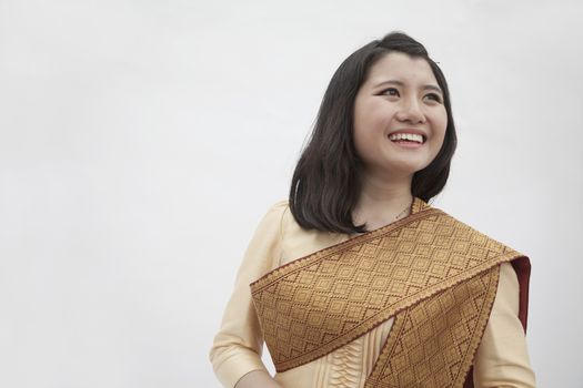 Portrait of smiling young woman in traditional clothing from Laos, studio shot