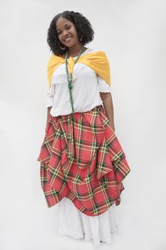 Portrait of smiling young woman wearing a traditional dress from the Caribbean, studio shot