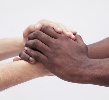 Two young men clasping each others hands, close-up, studio shot