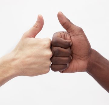 Two young men giving each other the thumbs up sign, close-up, studio shot