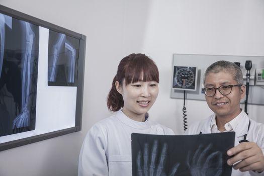Two doctors looking at an x-ray of hand bones