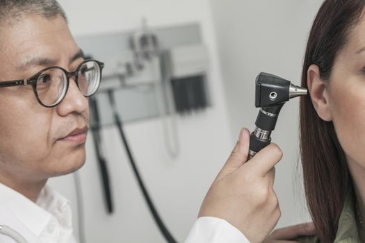 Close-Up of doctor checking the ears of a patient