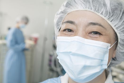 Portrait of surgeon with surgical mask and surgical cap in the operating room 
