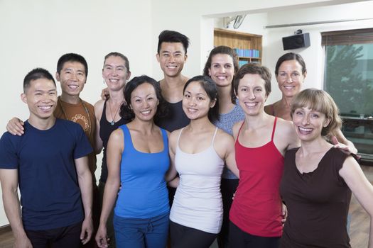 Group portrait of smiling group of people in a yoga studio